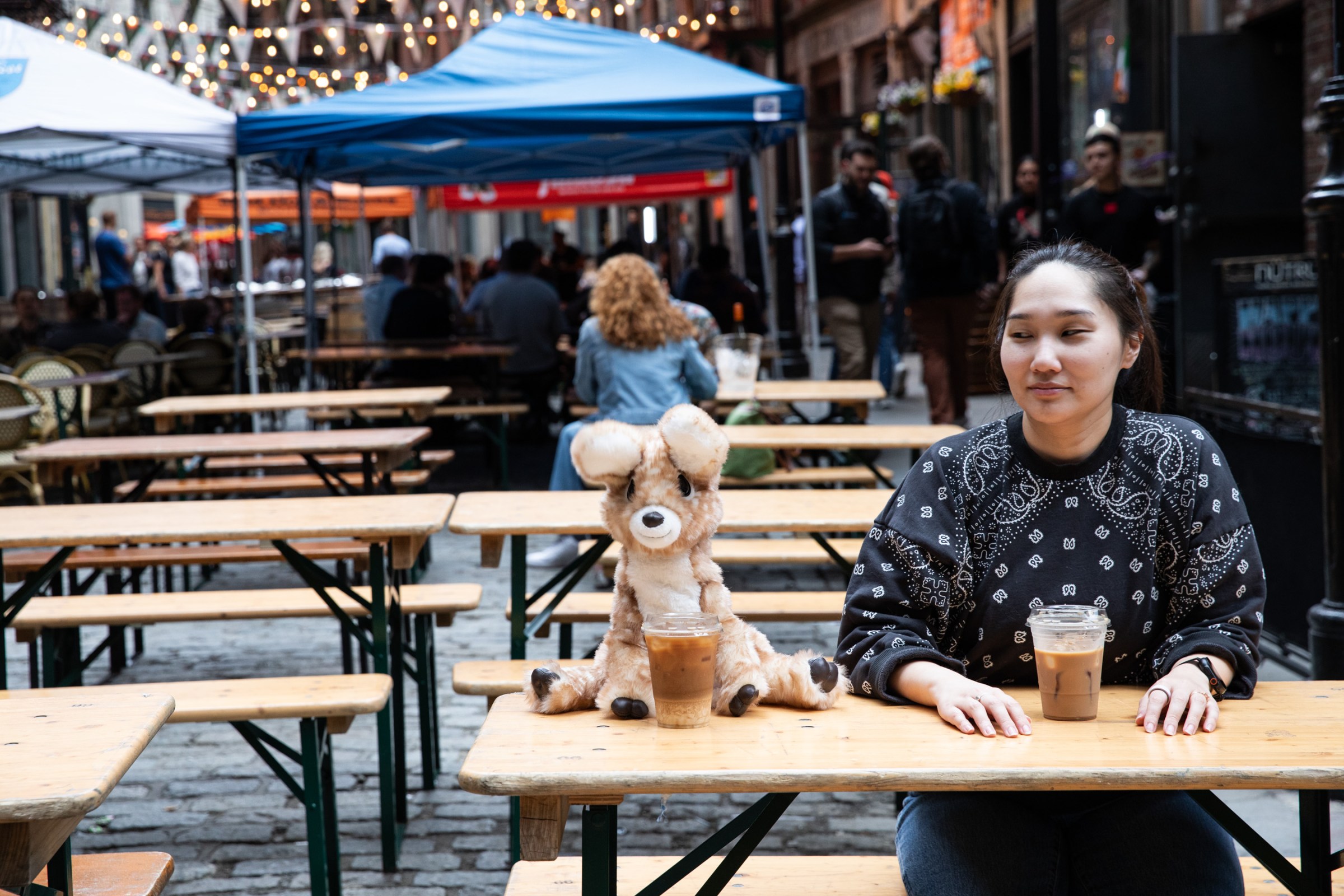 Senior reviewer Victoria Song sitting with her Fawn Friend Coral at an outdoor seating area with coffees.